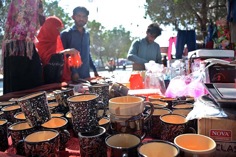 People buying old crockery from a roadside stall