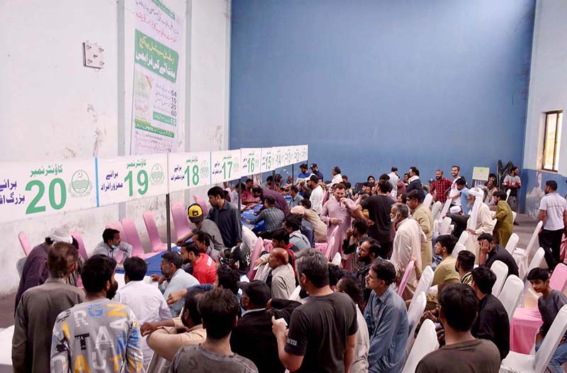 A large number of people are waiting for their turn to receive the Ramadan package free flour distribution token by the Prime Minister of Pakistan, Chief Minister of Punjab at Anwaar Club