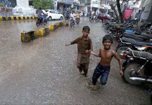 Children enjoy playing in rain water in the city