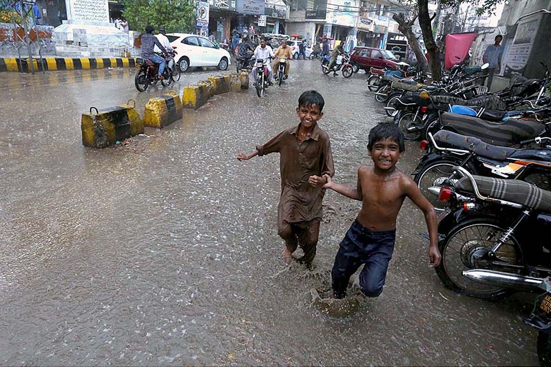 Children enjoy playing in rain water in the city