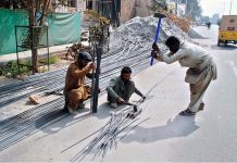 Laborers cutting off iron bars on the roadside that might cause any mishap