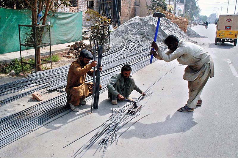 Laborers cutting off iron bars on the roadside that might cause any mishap