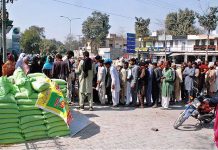 A large number of people in queue to get flour on government subsidized rate from a stall along the roadside