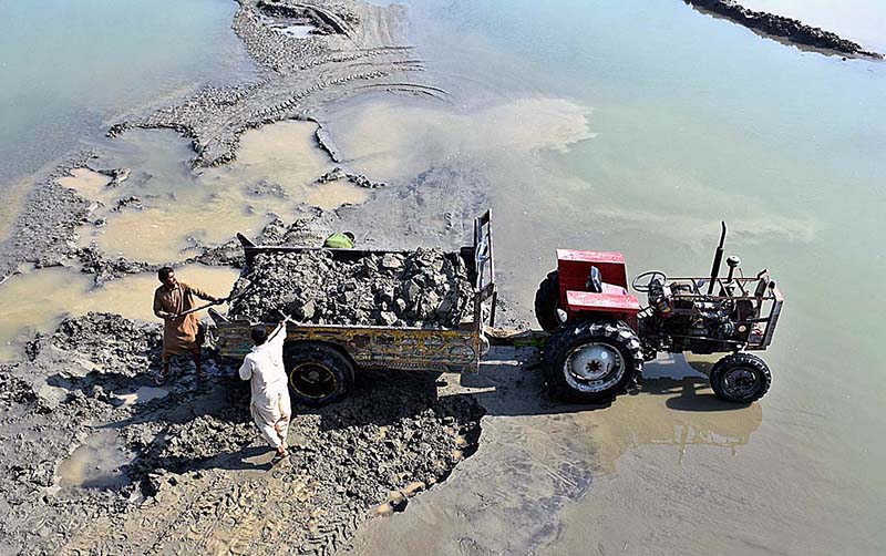 Laborers loading sand on tractor trolley for construction purpose at Rice Canal to supply to the customers