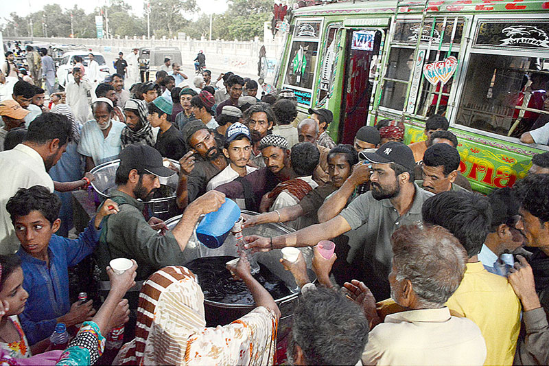 Volunteers distributing sweet drink among people at Iftar organized by Saylani Welfare at Numaish area