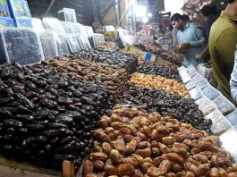 People are purchasing dates from vendors during holy fasting month of Ramzan at local market in the Provincial Capital