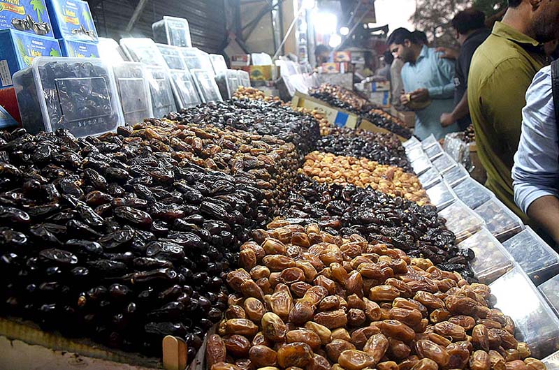 People are purchasing dates from vendors during holy fasting month of Ramzan at local market in the Provincial Capital