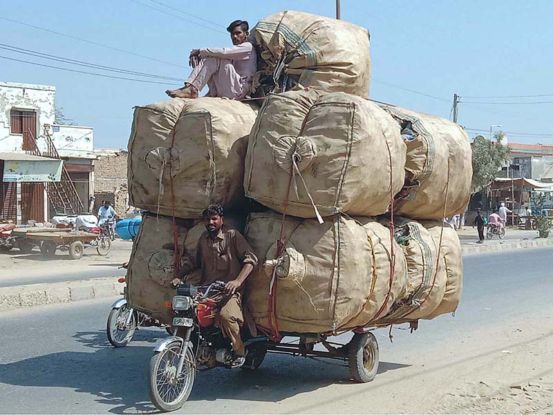 Tricycle loader loaded with empty bottles on the way to recycling factory