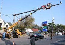Punjab Safe Cities Authority (PSCA) staffer busy in repairing the security cameras at Mall Road