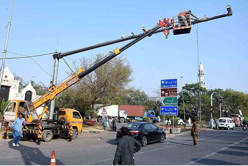 Punjab Safe Cities Authority (PSCA) staffer busy in repairing the security cameras at Mall Road