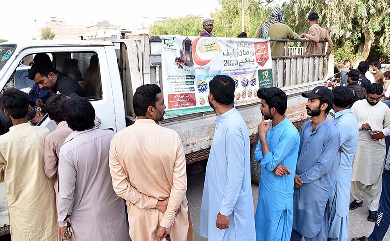 People standing in a queue to purchase flour bags on subsidized rate at Ramzan Bachat Bazar during holy month of Ramzan set up by the District Government near Railway Station