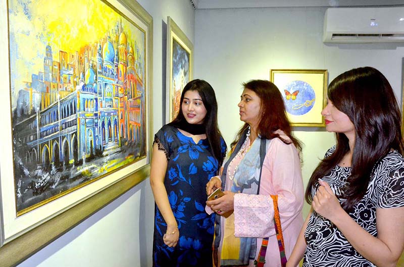 <em>Female art lovers are taking keen interest in the paintings displayed at YMCA during a painting competition</em>