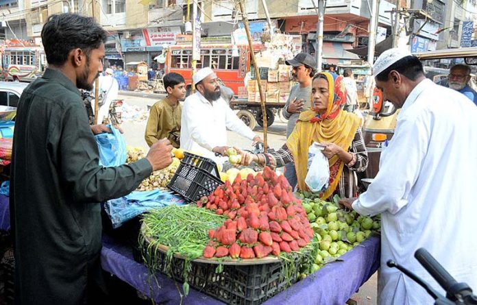 People purchasing fruits at a roadside stall