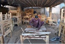 A carpenter preparing a large wooden table at his workplace
