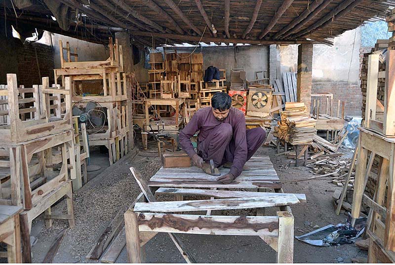 A carpenter preparing a large wooden table at his workplace