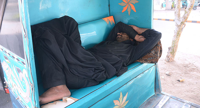 <em>A rickshaw driver sleeping during sunny day</em>