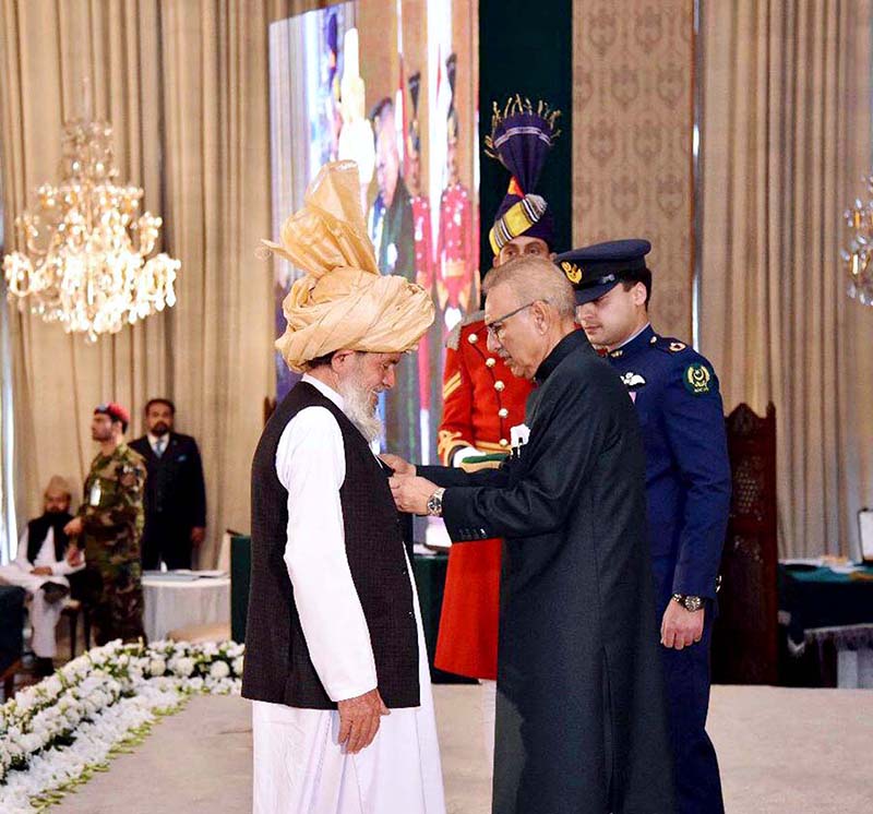 <em>President Dr. Arif Alvi conferring the Pakistan Civil Award of Sitara-i-Shujaat upon Malik Muhammad Hassan in recognition of his courage at the Investiture Ceremony on Pakistan Day, held at Aiwan-e-Sadr</em>