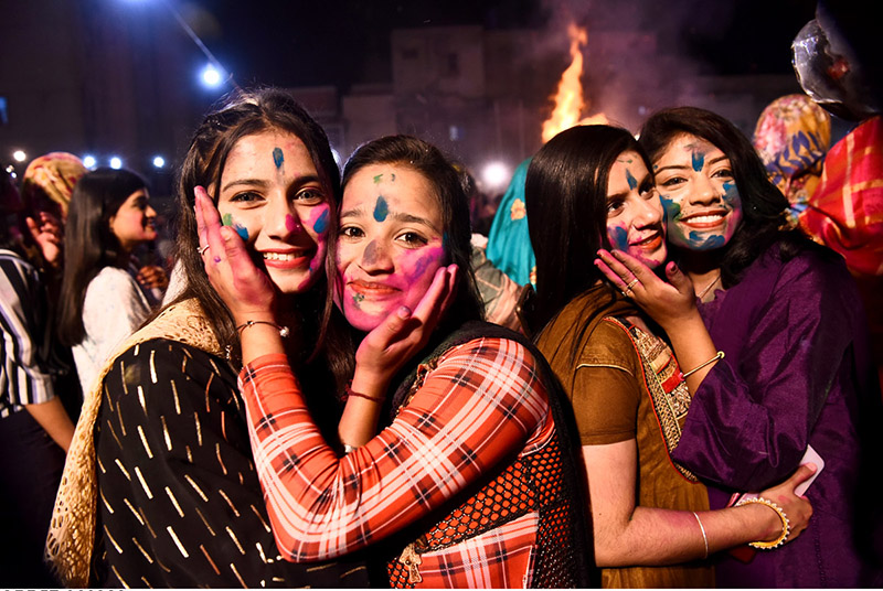 Girls of Hindu community applying colours on each other to celebrate the annual festival of holi at Soni Narayan Mandir