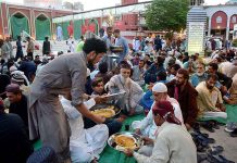 Volunteers distributing food among faithful for Iftari at New Memon Masjid on the first day of Ramzan