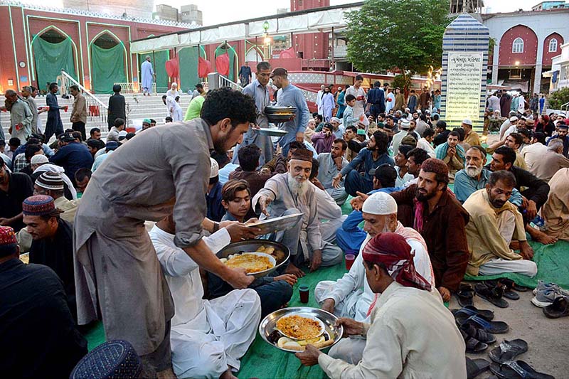 Volunteers distributing food among faithful for Iftari at New Memon Masjid on the first day of Ramzan