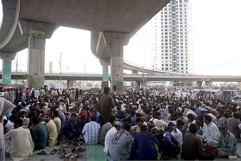 People are waiting to break their fast during the holy fasting month of Ramadan at a free meal distributing point at Qayumabad