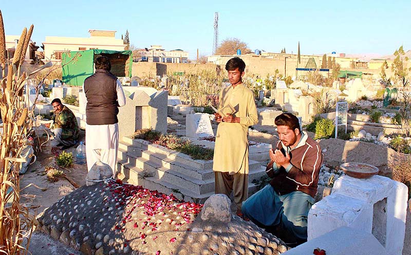 A person is offering prayer at a grave of his loved one on the occasion of Shab-e-Barat at Tando Yosuf Graveyard