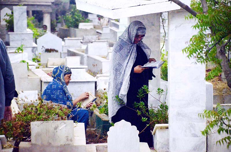 People Recite verses of Quran over the graves of their relatives on the occasion of Shab-e-Barat at graveyard