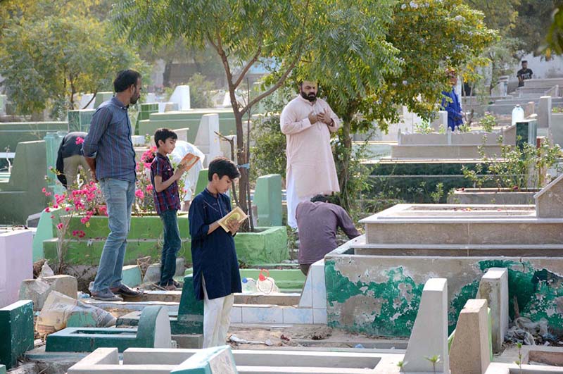 People Recite verses of Quran over the graves of their relatives on the occasion of Shab-e-Barat at graveyard