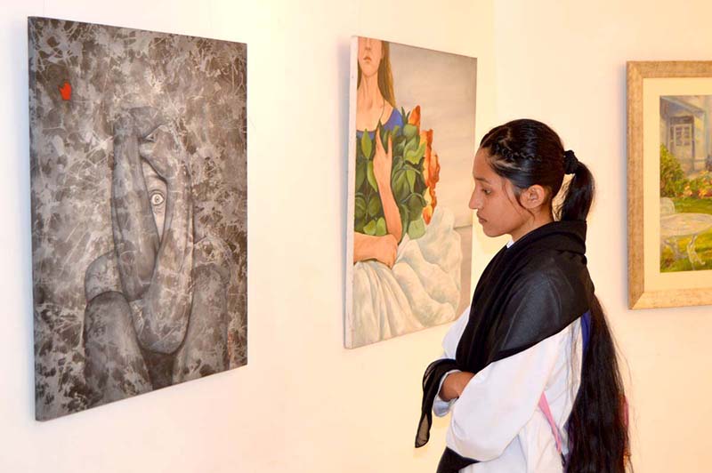 A girl visitor visiting Al Hamra Art Gallery on occasion of International Women Day