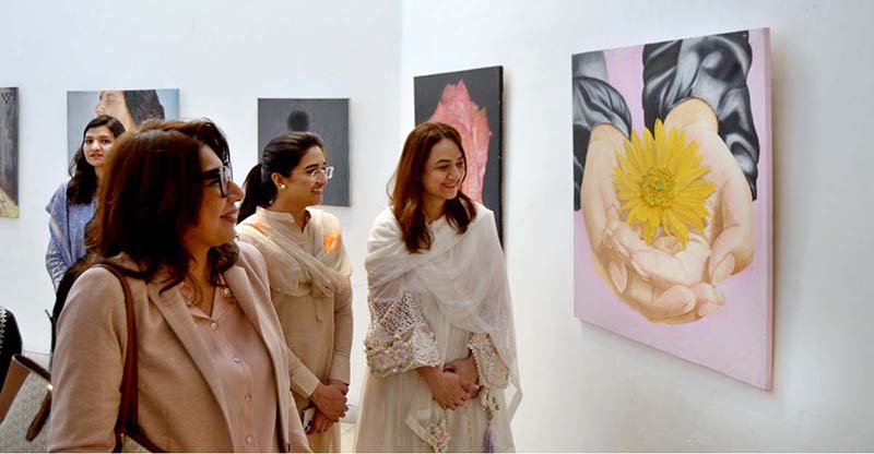 A girl visitor visiting Al Hamra Art Gallery on occasion of International Women Day