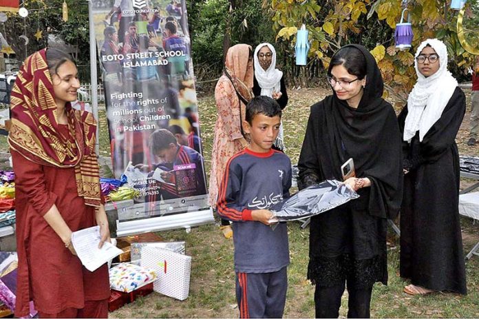 Volunteers are distributing Eid gift among to street children at Rawal town Local Park