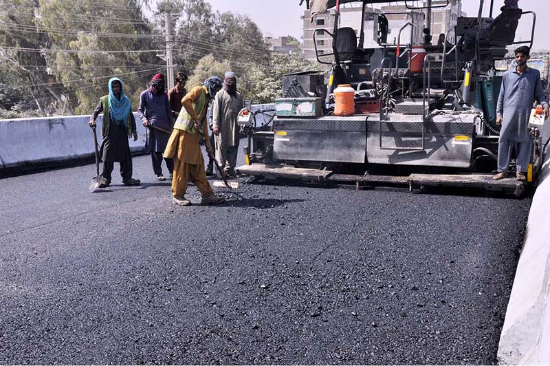 Labourers busy in construction work of IJP Road with the help of Heavy machinery during development work in the city