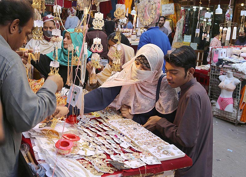 A family purchasing jewelry during Eid shopping in preparation of upcoming Eid-ul-Fitar at Resham Bazaar.
