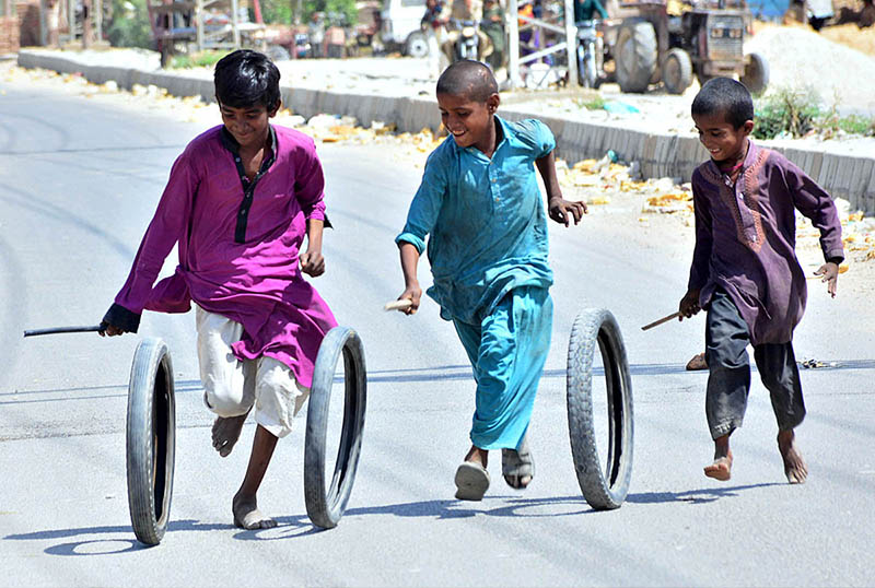 Children enjoying and playing with tires at Latifabad.