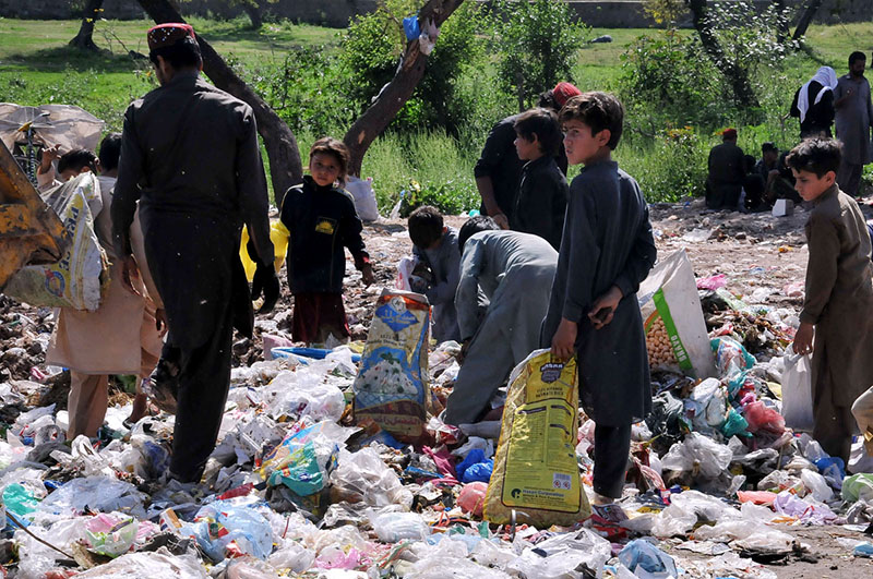 Gypsy children are searching valuables from a garbage near Khanna Pul area