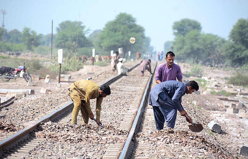 Railway workers busy in repairing a railway track.
