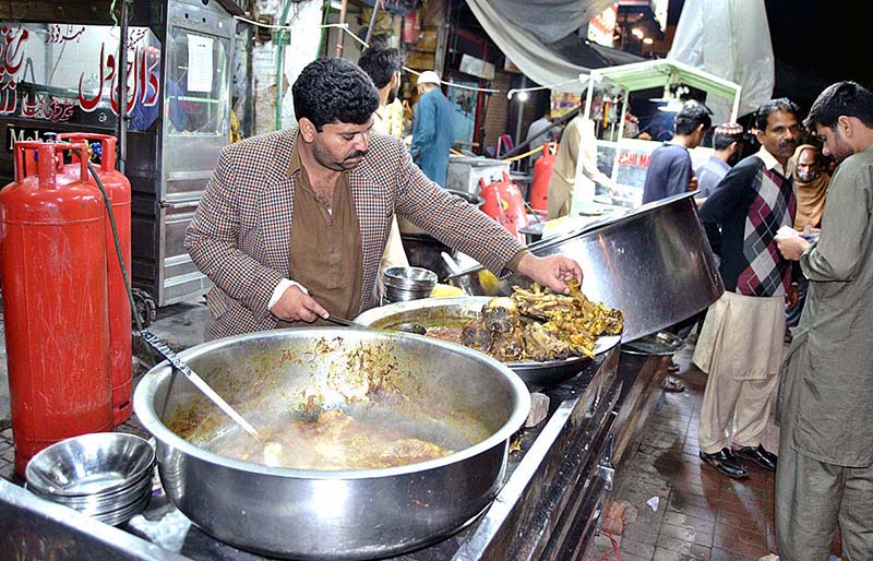 A vendor is displaying and selling traditional food to customers for sehri at Anarkali Bazaar during holy fasting month of Ramzan-ul-Mubarak