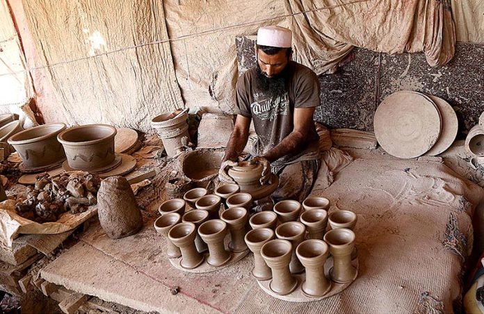 A craftsman busy preparing clay-made stuff at his workplace