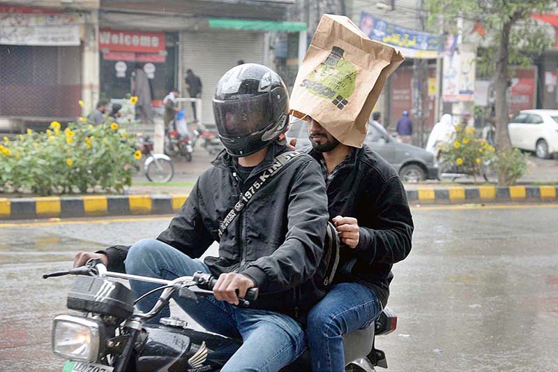 Commuters on his bike moving towards his destination during rain in the Provincial Capital