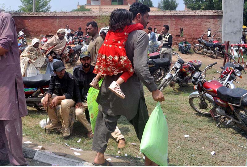 A man carrying free flour bags and his daughter at Mela Mendi.