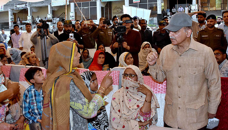 Prime Minister Muhammad Shehbaz Sharif is interacting with deserving people during his visit to free flour distribution Center at Iqbal Stadium.