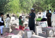 People offering dua at the grave of their family members on the occasion of first day of Eidul Fitr in a local graveyard