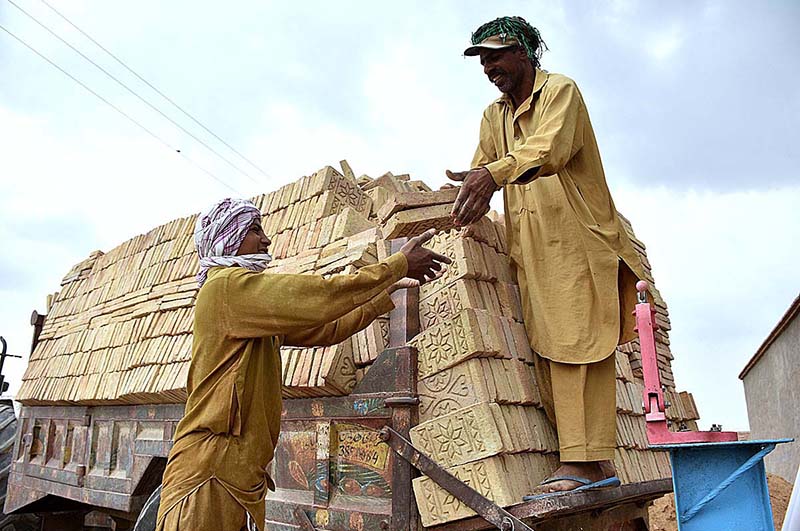 Labourers busy in loading bricks on tractor trolley at a kiln as the world marks International Labour Day. May 1st, International Workers' Day, commemorates the historic struggle of working people throughout the world. In 1884, the Federation of Organized Trades and Labour Unions passed a resolution stating that eight hours would constitute a legal day's work from and after May 1, 1886