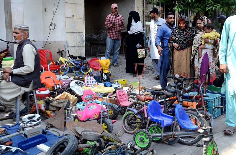 Customers buying used toys from a roadside vender