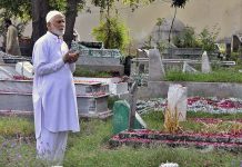A person offering fateha on the grave of his family member on the occasion of Eidul Fitr