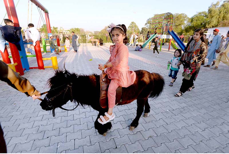 Children enjoying Seesaw at Sher Khan Shaheed Amusement Park on the 2nd day of Eid-ul Fitr celebrations
