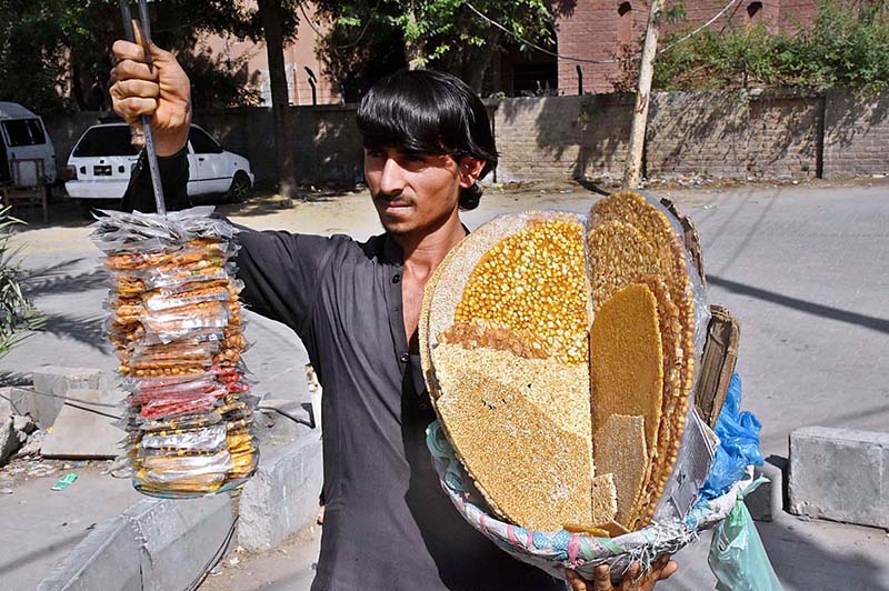 A street vendor selling traditional sweet items in front of Sheikh Zayed Children Hospital