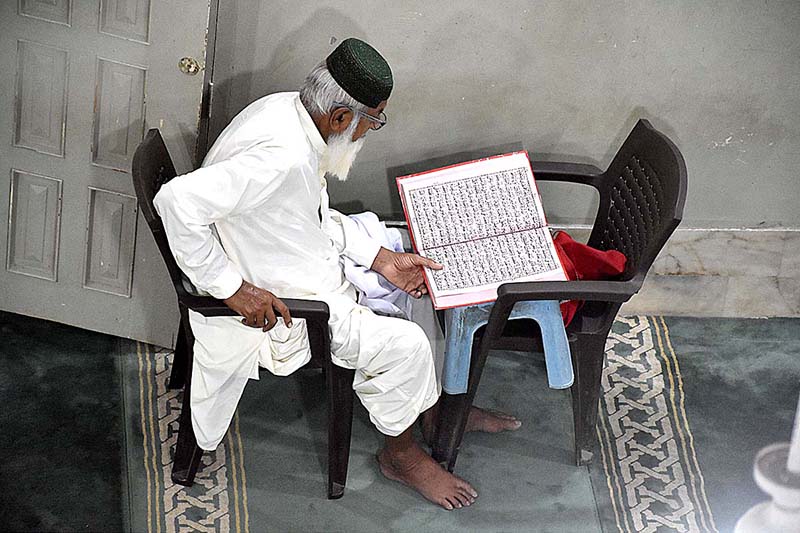 An old man is reciting the Holy Quran in Madarsa Jamia Ishatul Quran Wal-Hadees Dodai Road during the holy fasting month of Ramzan