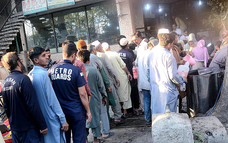 People standing in queue to get free drink distributed by the volunteers