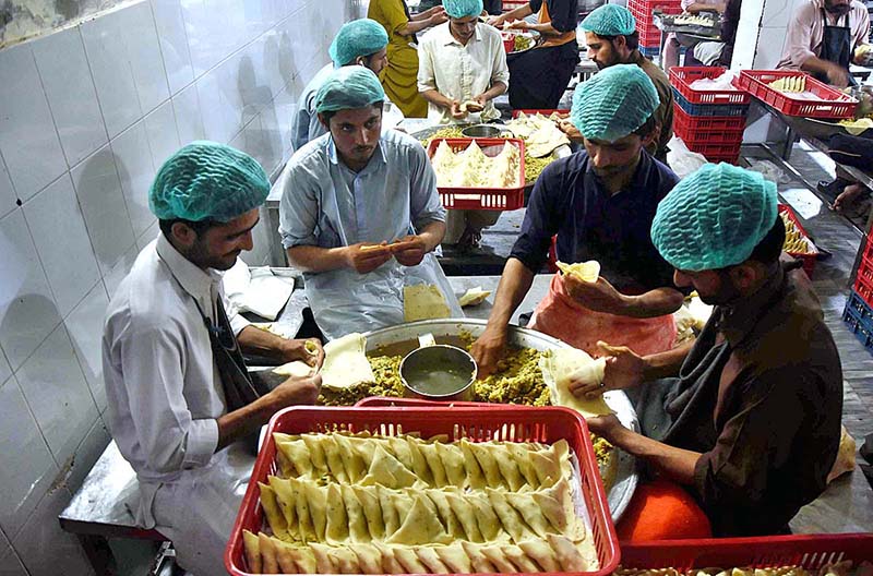 Workers busy in preparing samosas before frying at their workplace during the Holy Month of Ramadan-ul-Mubarak.